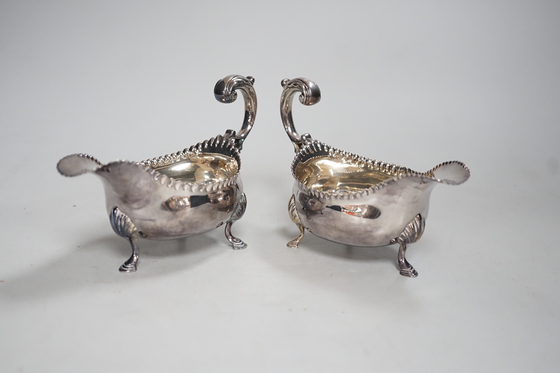 A pair of early George III silver sauceboats, with flying scroll handles, maker, CH, London, 1768, length 15.5cm, 10.4oz.